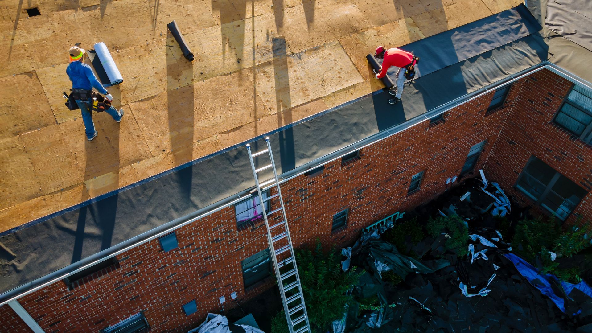 Two skateboarders on the roof of a building